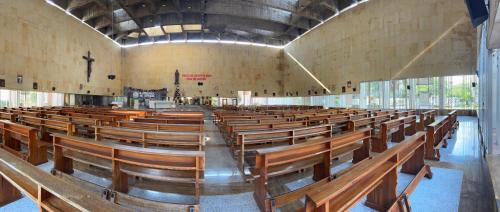 an empty church with rows of wooden benches at Hotel Los Puentes Comfacundi in Girardot