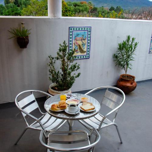 Posada del Arbol في كابيلا ديل مونتي: طاولة عليها كرسيين وصحن طعام