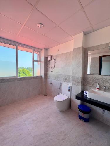 a large bathroom with a toilet and a sink at Alnaro Hotel & Resort in Moratuwa