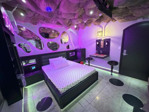 a bedroom with a bed in a room with purple lighting at Cachoeiras Motel - Hotel in Sao Paulo