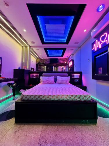 a bedroom with a bed in a room with neon lights at Cachoeiras Motel - Hotel in Sao Paulo