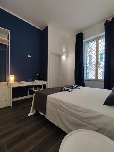 una camera da letto con un letto grande e una scrivania di Donna Oliva Guest House a Palermo