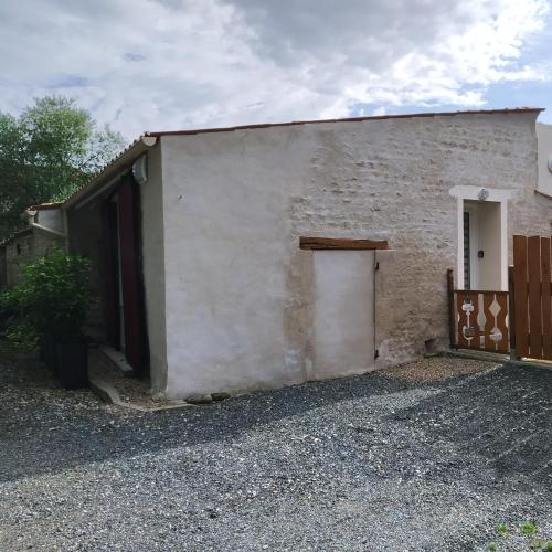 - un bâtiment blanc avec une porte et un portail dans l'établissement Quatre As - Studio au calme, à Saint-Christophe