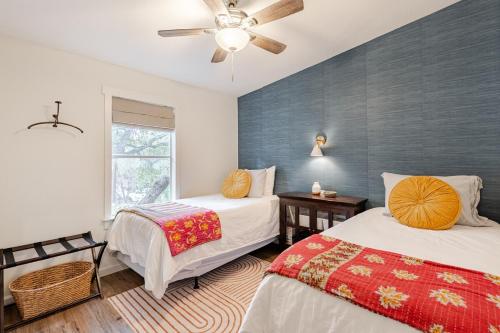une chambre avec deux lits et un ventilateur de plafond dans l'établissement River Access at Blanco River, Charming Big Cottage, à Wimberley