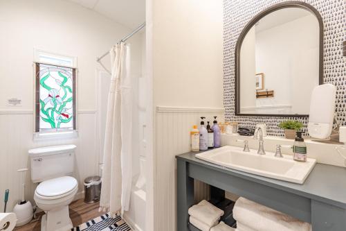 une salle de bain avec un lavabo, des toilettes et un miroir dans l'établissement River Access at Blanco River, Charming Big Cottage, à Wimberley