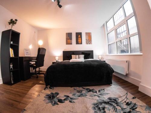 a bedroom with a bed and a desk and a window at SAV Apartments Rutland Leicester in Leicester