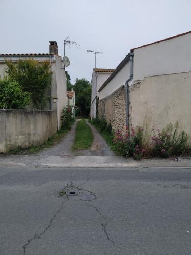 une rue vide dans une ruelle avec des bâtiments et des fleurs dans l'établissement Quatre As - Studio au calme, à Saint-Christophe