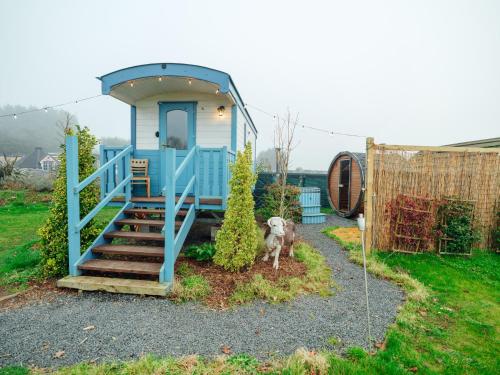 a dog standing in front of a tiny house at Sunset Retreats The Anna Mae in Worcester