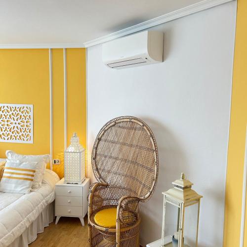 a room with a rattan chair and a bed at Retiro verde en Madrid in Quintana