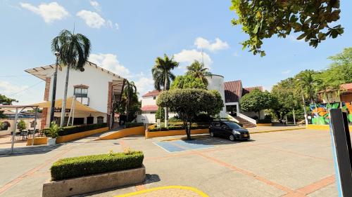 a car parked in a parking lot next to a building at Hotel Los Puentes Comfacundi in Girardot
