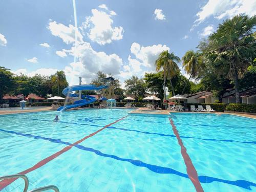 a large swimming pool with a water slide at Hotel Los Puentes Comfacundi in Girardot