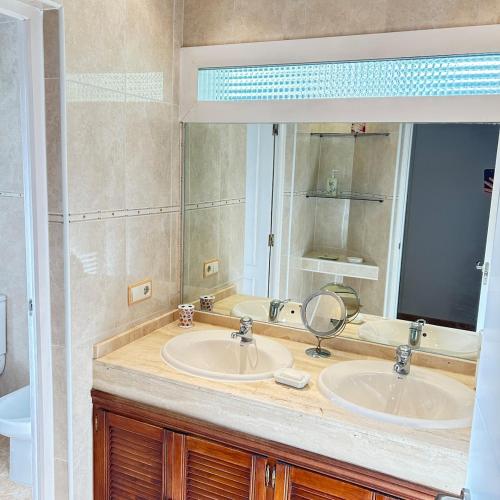a bathroom with two sinks and a mirror at Retiro verde en Madrid in Quintana
