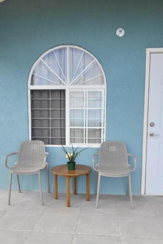 two chairs and a table in front of a window at Irie Rock Cottage - Close to the Beaches and Attractions, Spa Treatment- Discovery Bay, St Ann in Discovery Bay