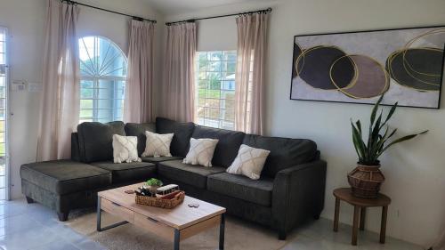 a living room with a couch and a coffee table at Irie Rock Cottage - Close to the Beaches and Attractions, Spa Treatment- Discovery Bay, St Ann in Discovery Bay