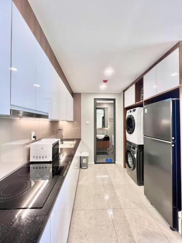 a kitchen with white cabinets and a stainless steel refrigerator at Vinh Hoi Apartments - Luxury Apartment Furnished Suites in Ho Chi Minh City