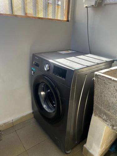 a washing machine is sitting in a room at GCurtway Homes Nyayo 3 bedroom in Nairobi