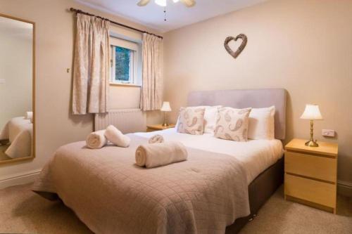 Un dormitorio con una cama grande con toallas. en Thomas Fold Flat, en Ambleside