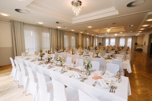 a large banquet hall with white tables and white chairs at Stadthotel GARNI Pinkafeld in Pinkafeld