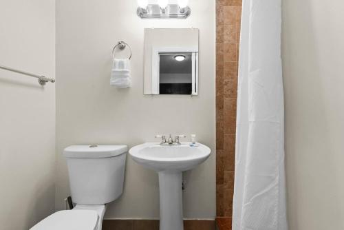 Un baño blanco con inodoro y lavabo. en Cozy Studio in Lake Worth with Pool Complex, en Lantana