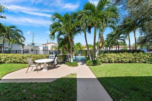 a patio with a table and chairs and palm trees at Cozy Studio in Lake Worth with Pool Complex in Lantana
