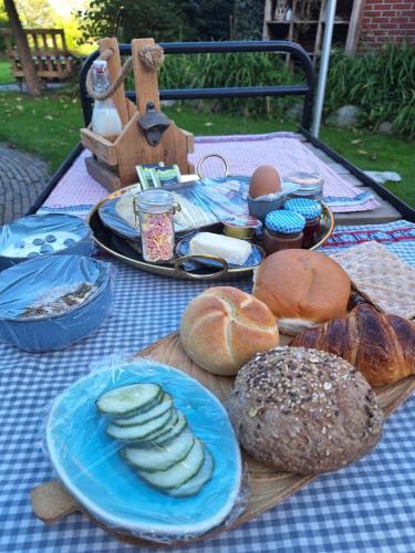una mesa de picnic con pan y otros alimentos. en Knusse loft de Hooizolder, en Daarle