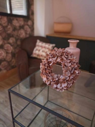 a glass table with a vase on top of it at La Ferme de la Cour in Herbeumont
