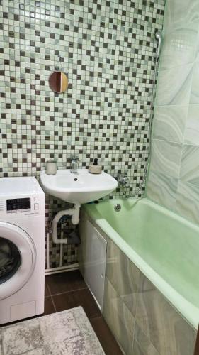 a bathroom with a sink and a washing machine at Air-Moldova 25 in Chişinău
