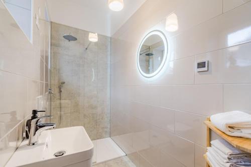 a white bathroom with a sink and a shower at Apartment Vandora in Idrija