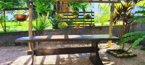 a wooden bench sitting in a garden with plants at Pousada Canto Dos Pássaros Araras Canindé in Alto Paraíso de Goiás