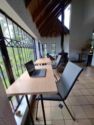 a laptop on a wooden table in a room with windows at House Life in La Calera