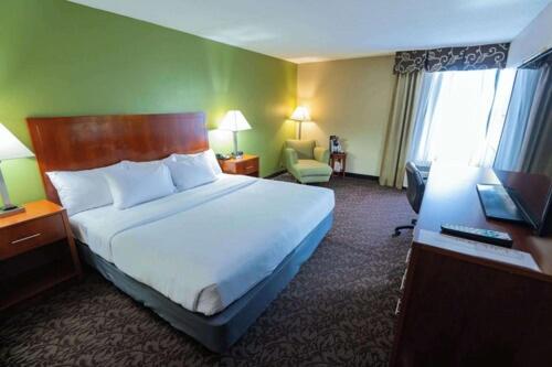 a hotel room with a large bed and a desk at Quality Inn & Suites Downtown Mansfield in Mansfield