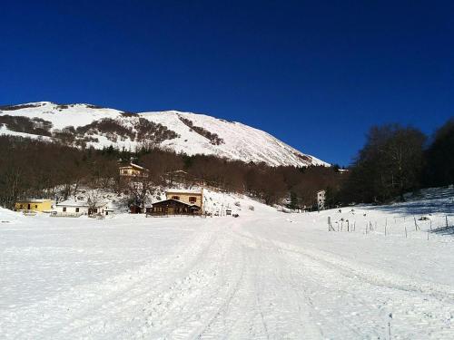 a snow covered mountain with a house in the distance at Passo del Mattino in Locati