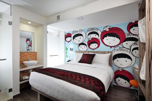 a bedroom with a mural of people on the wall at Hotel Clover The Arts in Singapore