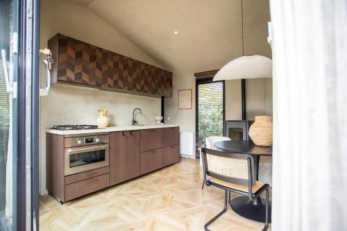 a kitchen with a table and a sink and a stove at Luxe Hottub Japandi Tiny house in het Bos in Nunspeet