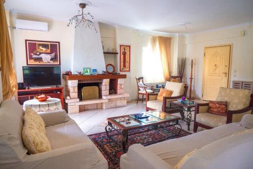 a living room with a couch and a fireplace at Villa Despoina in Platamonas