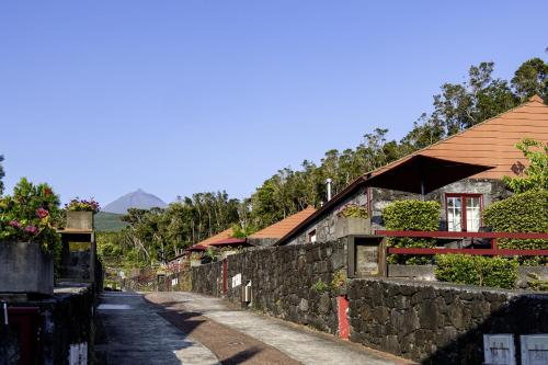a street with buildings and a stone wall at Aldeia das Adegas in São Roque do Pico