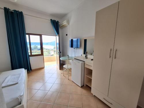 a kitchen with a sink and a table with a window at Hotel Sirena in Vlorë