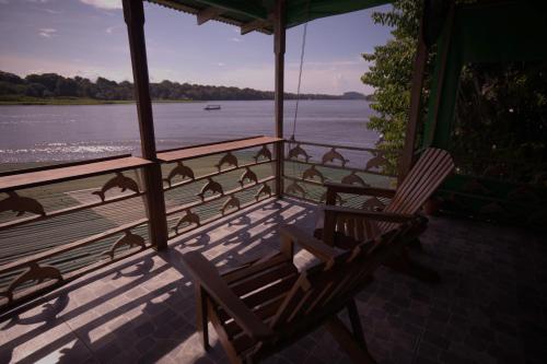 a group of birds sitting on a porch overlooking the water at Casa Los Delfines in Tortuguero