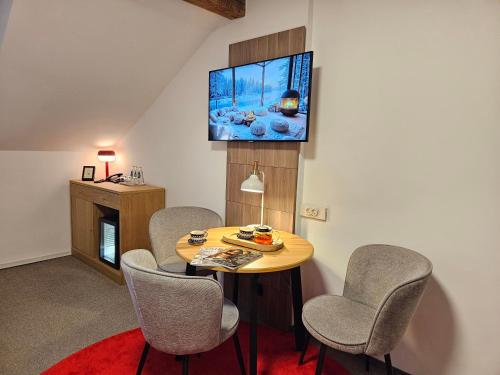a living room with a table and chairs and a tv at Hotel Protea Bolesławiec in Bolesławiec
