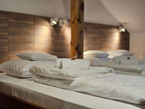 a group of white beds sitting in a room at Hotel Protea Bolesławiec in Bolesławiec
