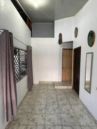a room with white walls and a hallway with a door at Casa Los Delfines in Tortuguero
