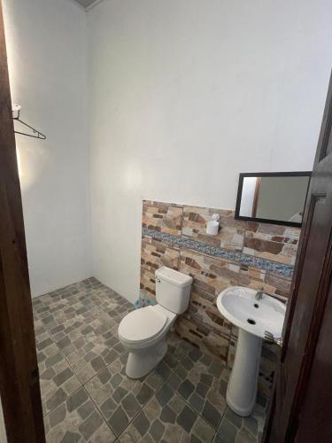 a bathroom with a toilet and a sink at Casa Los Delfines in Tortuguero