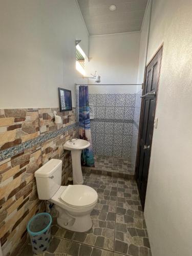 a bathroom with a toilet and a shower at Casa Los Delfines in Tortuguero
