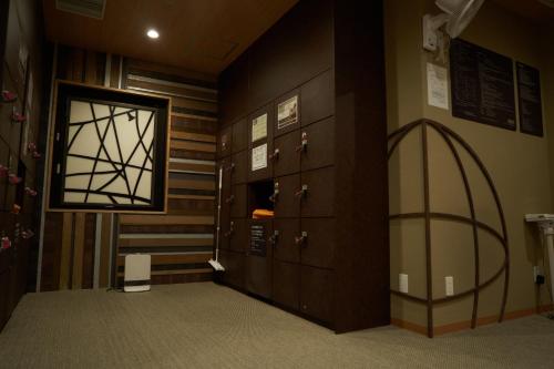 a hallway with lockers and a door in a room at Dormy Inn Higashi Muroran in Muroran