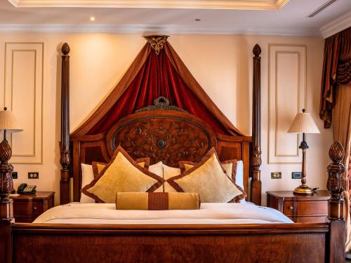 a bedroom with a large bed with a red canopy at Plaza Grande Hotel in Quito