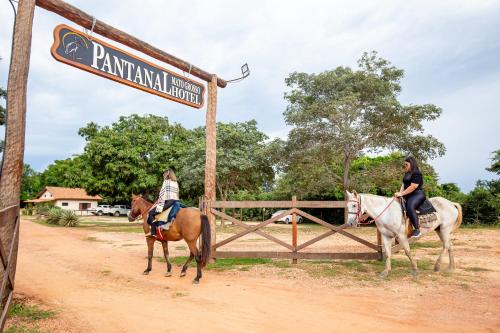 two people riding horses on a dirt road at Hotel Pantanal Mato Grosso in Poconé
