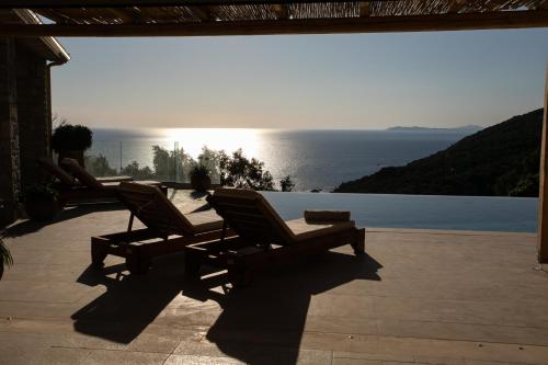 two chairs on a patio with a view of the ocean at Villa Elysium Parga in Parga