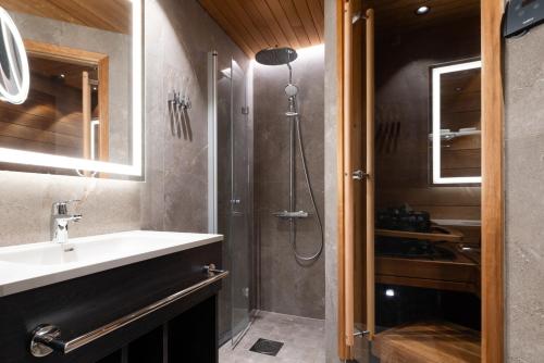 a bathroom with a sink and a shower at Lapland Hotels Ylläskaltio in Äkäslompolo