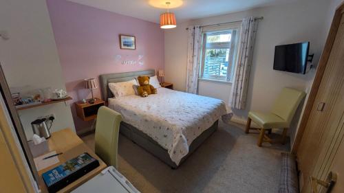 a bedroom with a bed with a teddy bear on it at Willowdale B&B in Breakish