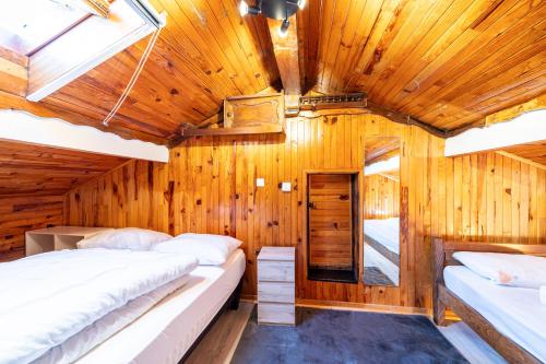 two beds in a room with wooden walls at Chalet les aiguilles in Albiez-Montrond
